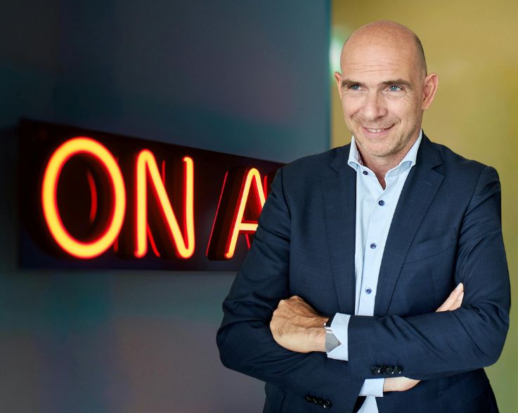 Foto von Frank Hendricks vor Neonlicht "On Air".